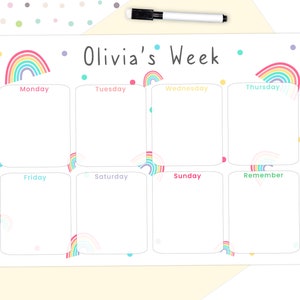 May include: A white weekly planner with rainbow details and the text "Olivia's Week." The planner has seven sections for each day, plus a "Remember" section. A black marker is included.