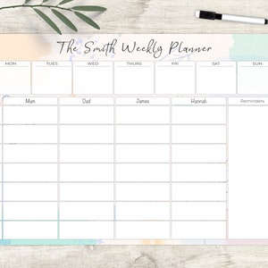 May include: A weekly planner with a pastel watercolour design. The planner is labelled "The Smith Weekly Planner" and has sections for each day, with spaces for family members and reminders. A black marker is visible.
