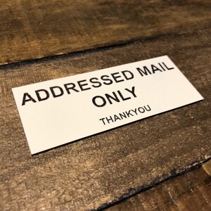 May include: White sign with black text that reads "Addressed Mail Only" and "Thankyou".