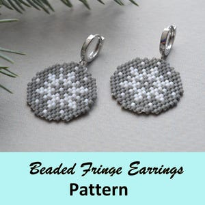 May include: A pair of beaded fringe earrings with a snowflake pattern. The earrings are gray with white accents and silver-colored hoops. The text "Beaded Fringe Earrings Pattern" is at the bottom of the image.