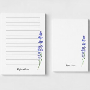 Pode incluir: Duas folhas de papel de carta brancas com uma ilustração em aguarela de um ramo de lavanda roxo no lado direito. A folha esquerda tem linhas pretas horizontais e ambas exibem o nome Kaylee Marie em letra cursiva preta na parte inferior.