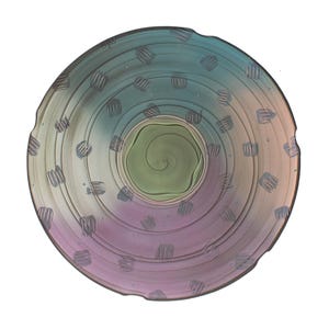 May include: A handmade, decorative ceramic bowl with a spiral design in the center. The bowl features a color gradient from green to purple, with blue and gray accents. The rim has a textured edge, and the bowl is decorated with small, gray, hatched patterns.
