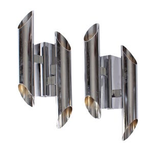 May include: Pair of chrome wall sconces. Each sconce features three cylindrical tubes with angled openings. The sconces are mounted on a rectangular base. The polished chrome finish reflects light, creating a modern aesthetic.
