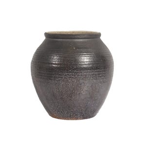 May include: A dark brown ceramic vase with a rounded body and a slightly flared lip. The vase has a textured surface and a subtle sheen.