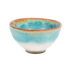 May include: A small, handcrafted ceramic bowl with a rounded shape. The bowl features a gradient of colors, with a white base, transitioning to turquoise, and a brown rim. The bowl is likely used for serving food or as a decorative item.