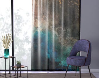 Può includere: Tenda d'arte astratta con una miscela di colori tra cui verde acqua, marrone e grigio. Una moderna sedia blu imbottita con gambe scure è vicino alla tenda. Sono visibili anche due piccoli tavolini neri con piani in rame e un vaso turchese.