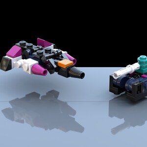 Könnte beinhalten: Zwei kleine, bunte Lego-ähnliche Spielzeug-Raumschiffe. Das Raumschiff links ist schwarz, weiß und lila mit orangefarbenen Akzenten. Das Raumschiff rechts ist schwarz, türkis und lila.