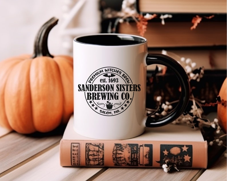 May include: White ceramic mug with a black handle and black rim. The mug features a black and white logo that reads "Premium Witches Brew est. 1693 Sanderson Sisters Brewing Co. Salem, MA."