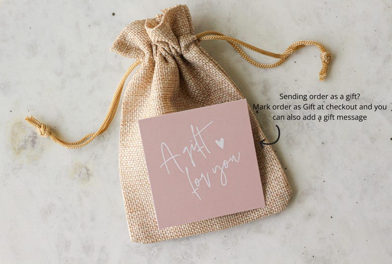 May include: A tan burlap drawstring pouch featuring a square pink card with the white text A gift for you and a small heart icon. An arrow points to the card with the text Sending order as a gift? Mark order as Gift at checkout and you can also add a gift message.