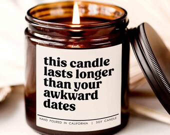 May include: A brown glass candle jar with a white label that reads "this candle lasts longer than your awkward dates". The candle is hand-poured in California and is made with soy wax.