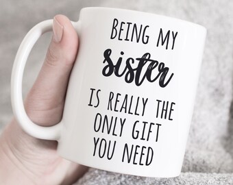 May include: White ceramic mug with black text that reads "Being my sister is really the only gift you need."