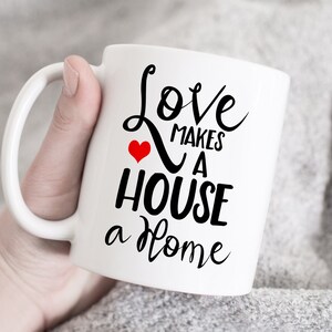 May include: White ceramic mug with black text that reads "Love makes a house a home" with a small red heart.