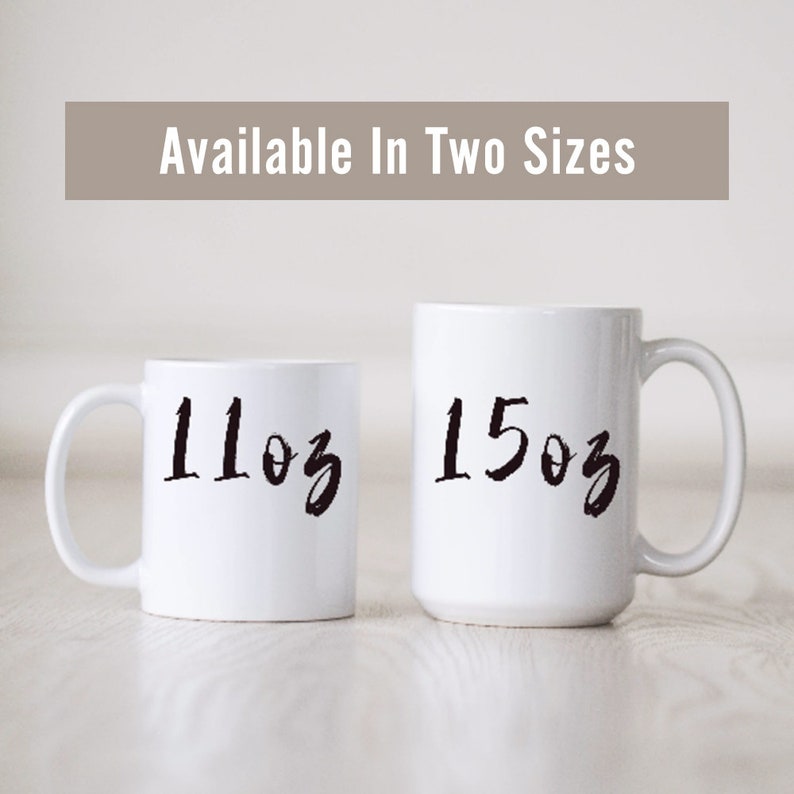 May include: Two white ceramic mugs with black handwritten text. The mug on the left says "11oz" and the mug on the right says "15oz".