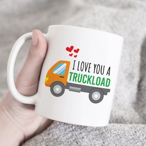 Peut inclure: Une tasse en céramique blanche avec un camion de dessin animé et le texte "Je t'aime un camion" en vert avec des cœurs rouges.