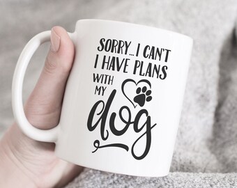 May include: White ceramic coffee mug with black text that reads "Sorry... I can't I have plans with my dog" and a paw print inside a heart.