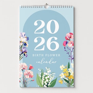 May include: A 2026 birth flower calendar with a light blue background. The calendar features the numbers "2026" in large white font, with the words "BIRTH FLOWER calendar" below. Floral illustrations in pink, yellow, and purple adorn the edges.