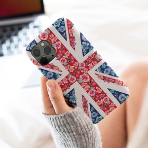May include: A white phone case with a floral pattern on a Union Jack flag design. The case has a camera cutout and is made of a durable material.