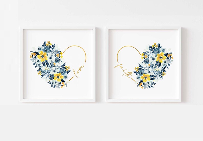May include: Two framed art prints featuring heart-shaped designs. Each heart is composed of blue and yellow watercolor flowers, with a gold outline. One print says "love" and the other says "faith" in gold script.