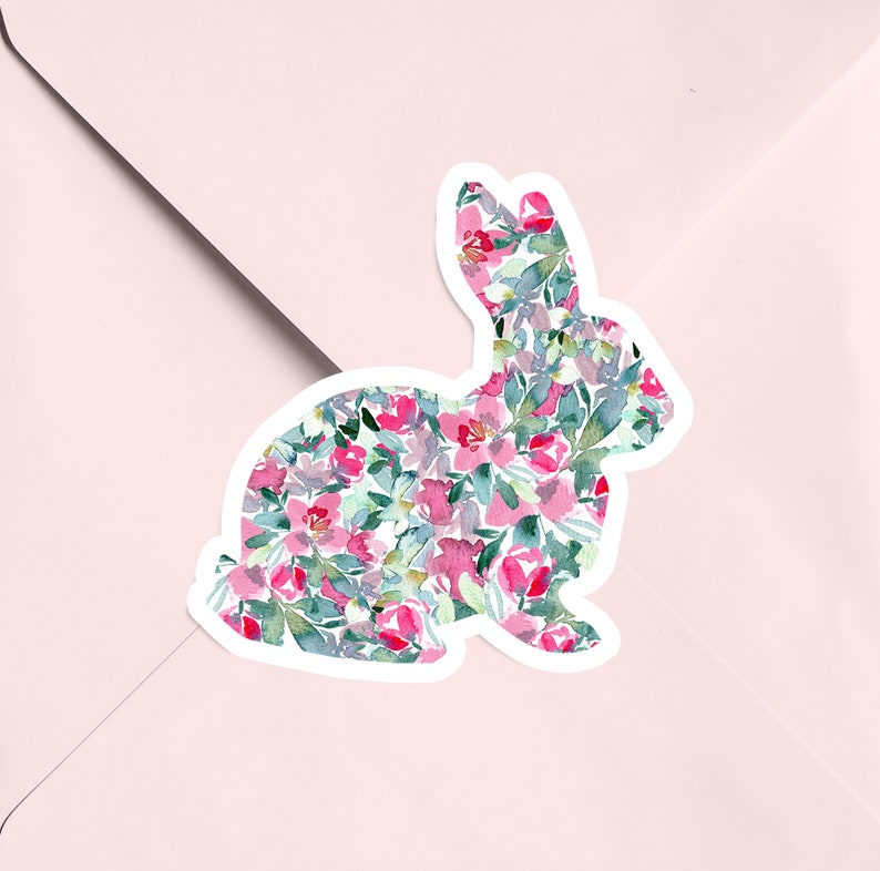 May include: A white silhouette of a rabbit filled with a watercolor pattern of pink and green flowers.