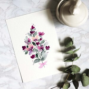 May include: A watercolour painting of a bouquet of pink and purple flowers with green leaves on a white background.