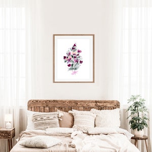 May include: A watercolour painting of a bouquet of purple and pink flowers with green leaves in a wooden frame.