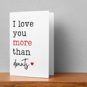 May include: White card with black text that reads "I love you more than donuts" with a red heart.