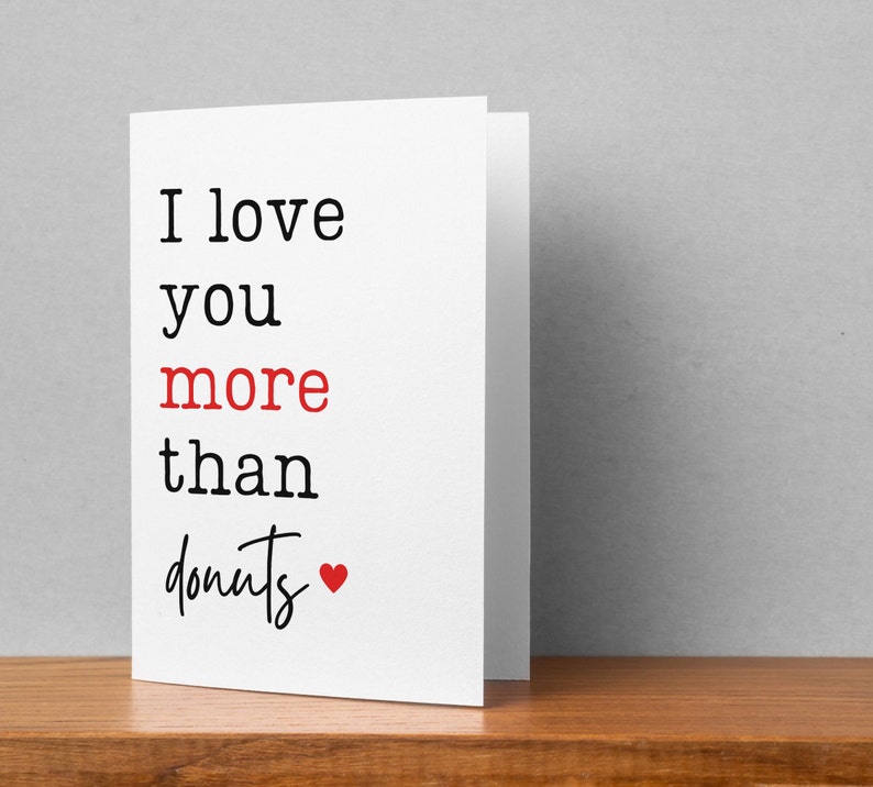 May include: White card with black text that reads "I love you more than donuts" with a red heart.