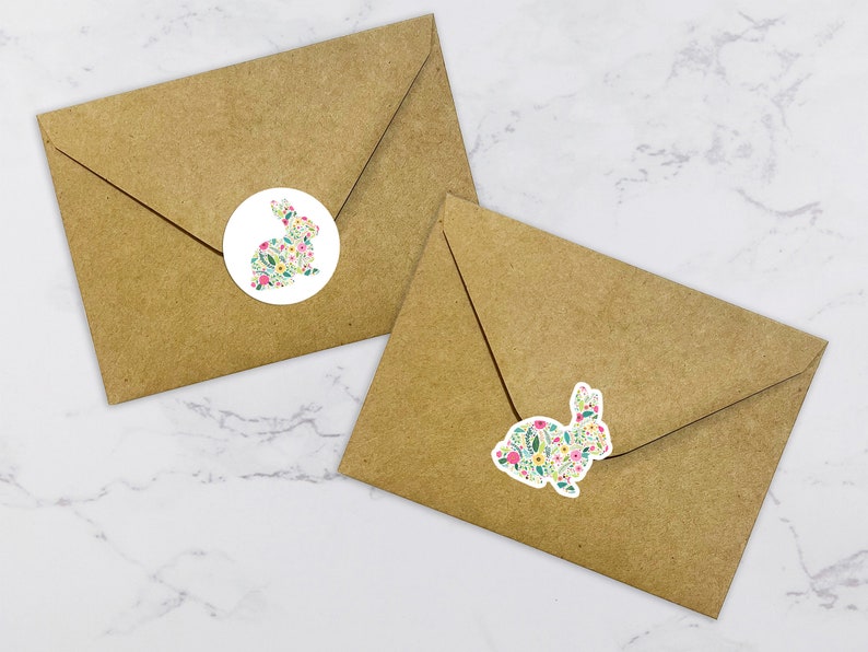 May include: Two brown envelopes with white round stickers featuring a floral bunny design. The bunny is outlined in black and filled with a pattern of pink, yellow, and green flowers.