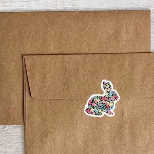 May include: A brown paper envelope with a floral patterned rabbit sticker on the front.