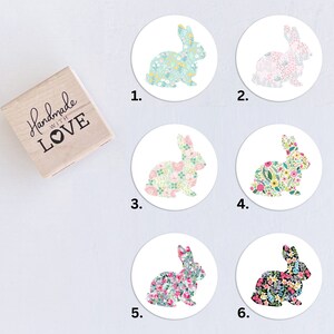 May include: Six round stickers with a floral bunny design. Each sticker features a different color scheme and floral pattern. The stickers are numbered 1 through 6.