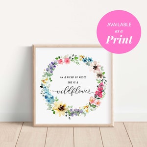 May include: A watercolor print with a floral wreath and the text "In a field of roses she is a wildflower".