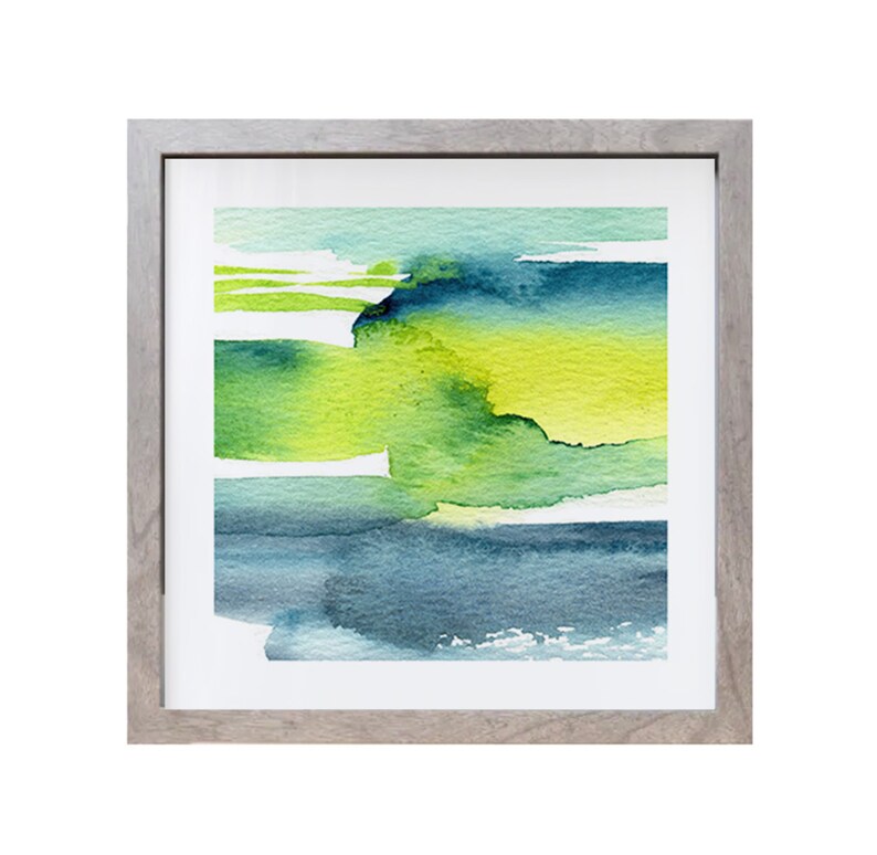May include: Abstract watercolor painting in a gray frame. The painting features shades of green, blue, and yellow, creating a layered and textured effect.