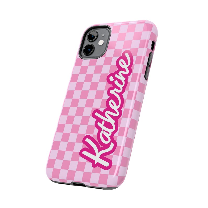 May include: Pink checkered phone case with the name Katherine written in a pink cursive font.