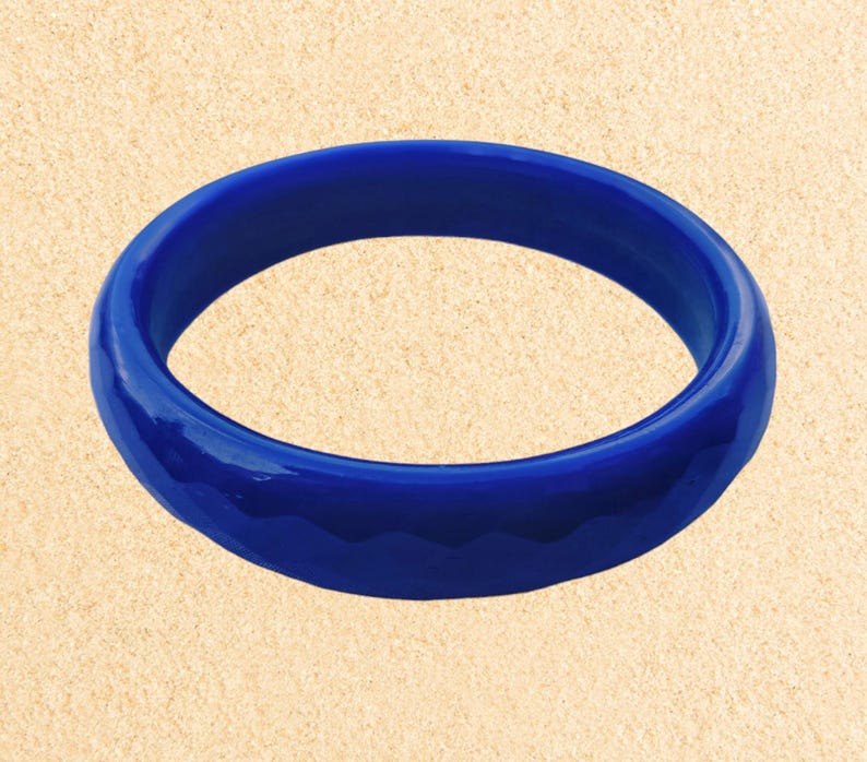 May include: A bright blue bangle bracelet with a smooth, glossy finish.