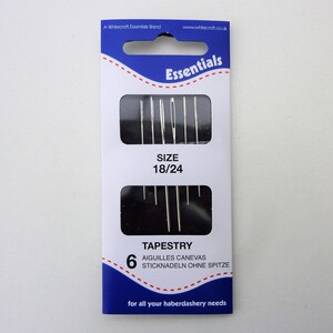 May include: A package of 6 tapestry needles, size 18/24, in a blue and white package with the text "Essentials" and "TAPESTRY" printed on it.