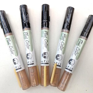 May include: Five gold metallic markers with black caps and the words "Plus Color" printed on the side. The markers are arranged in a fan shape.