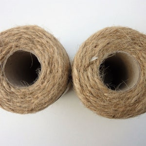 May include: Two spools of natural brown twine, each wound around a cardboard tube.