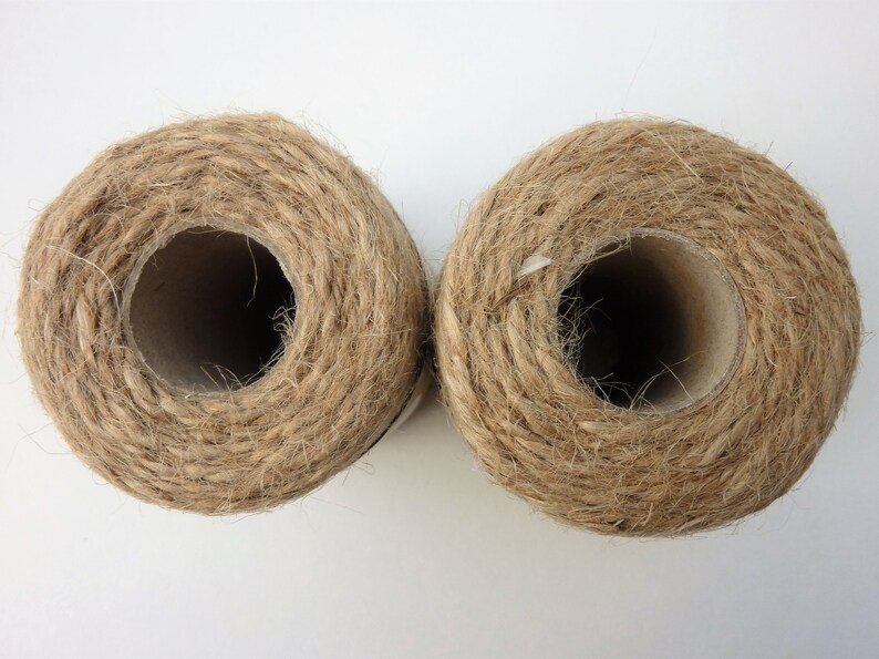 May include: Two spools of natural brown twine, each wound around a cardboard tube.