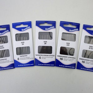 May include: Six packages of needles for tapestry and embroidery. The packages are labeled with the size of the needles and the type of needle. The needles are silver and come in packs of 6 or 16.