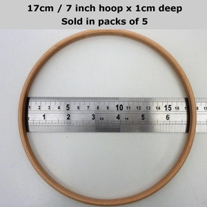 May include: A 7 inch wooden embroidery hoop with a 1 inch depth. The hoop is being measured with a ruler. 17cm / 7 inch hoop x 1cm deep. Sold in packs of 5.