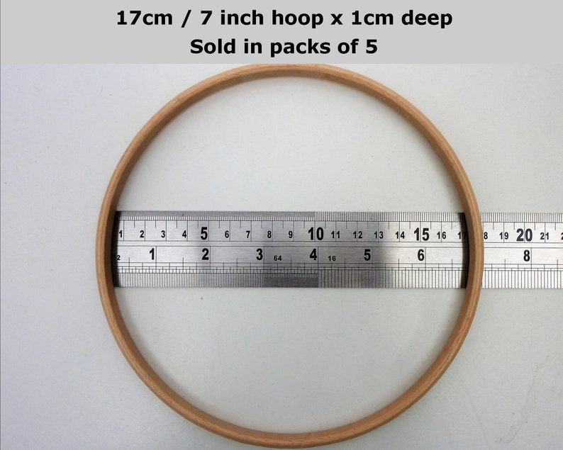May include: A 7 inch wooden embroidery hoop with a 1 inch depth. The hoop is being measured with a ruler. 17cm / 7 inch hoop x 1cm deep. Sold in packs of 5.