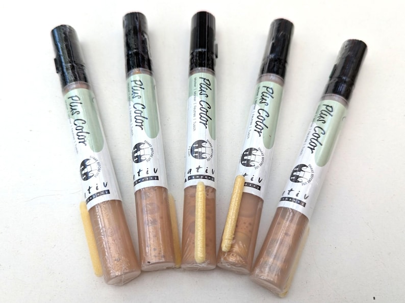 May include: Five gold metallic paint markers with black caps and a white label that says "Plus Color" and "tiv".