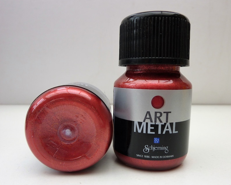 K&ouml;nnte beinhalten: Zwei Flaschen roter Metallic-Farbe mit der Aufschrift "Art Metal" von Schjerning. Die Flaschen werden in D&auml;nemark hergestellt und haben eine leuchtende rote Farbe.