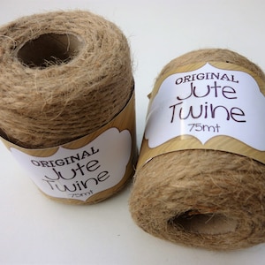 May include: Two spools of natural brown jute twine, each with a white label that reads "ORIGINAL Jute Twine 75mt".