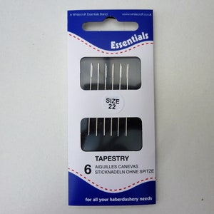 May include: A package of 6 tapestry needles, size 22, in a blue and white package with the text "Essentials" and "Tapestry" on it.