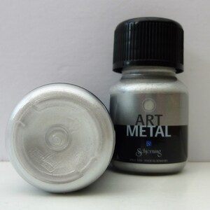 K&ouml;nnte beinhalten: Eine kleine Flasche silberner Metallic-Farbe mit der Aufschrift "Art Metal" von Schjerning. Die Flasche wird in D&auml;nemark hergestellt.