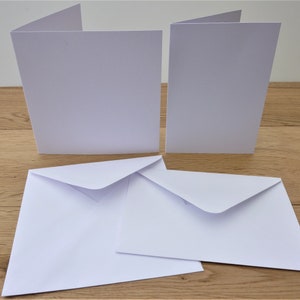 May include: Five blank white cards and envelopes. The cards are folded in half and the envelopes are open.