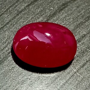 Puede incluir: Una piedra preciosa roja lisa de forma ovalada con un acabado pulido.