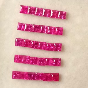 May include: Five rows of pink square-shaped gemstones, each row containing 10 gemstones.