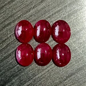 Könnte beinhalten: Sechs runde, rote Edelsteine mit einer glatten, polierten Oberfläche. Die Edelsteine sind in zwei Reihen zu je drei angeordnet.